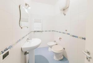 a white bathroom with a toilet and a sink at Casa del passero - Villa with Infinity Garden and Sea View in Forio d'Ischia +8 photos
