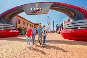 a group of people standing under a train station at PortAventura Hotel Lucy's Mansion - Includes unlimited access & Express wristband to PortAventura Park & Ferrari Land in Salou