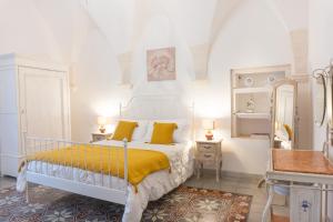 a bedroom with a white bed with yellow sheets at Masseria Luco in Martina Franca +226 photos