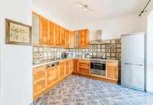 a kitchen with wooden cabinets and a white refrigerator at Casa del passero - Villa with Infinity Garden and Sea View in Forio d'Ischia