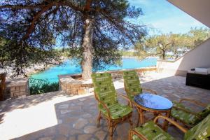 a patio with a table and chairs and a view of the water at Robinson Adriatic Queen in Gdinj