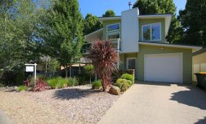 a house with a palm tree in front of a driveway at A Pear Tree Loft in Bright