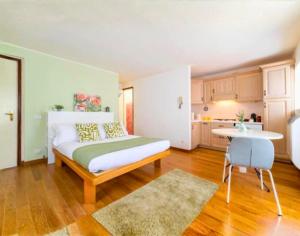 a bedroom with a bed and a table and a kitchen at Tiny Apartment on the Lake in Tremezzo
