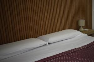 a bed with two pillows and a lamp on a table at Il Borgo civ 25 in Paola
