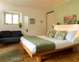 a bedroom with a large bed and a couch at Tiny Apartment on the Lake in Tremezzo