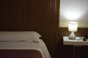 a bedroom with a bed and a lamp on a table at Il Borgo civ 25 in Paola +8 photos