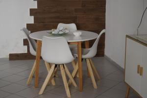 a table and four white chairs in a kitchen at Il Borgo civ 25 in Paola