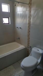 a bathroom with a toilet and a tub and a sink at Casa Vacacional in Cuenca