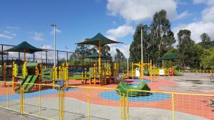 einen Spielplatz mit einem Spielbereich mit Rutschen und Sonnenschirmen in der Unterkunft Casa Vacacional in Cuenca