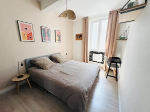 a bedroom with a bed and a desk in it at Le Petit Boursiers - hyper centre in Castres