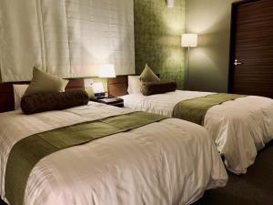 a hotel room with two beds with white sheets at scène セヌ in Daisen +26 photos