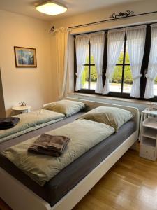 two beds sitting in a room with a window at Casa pasa - Idylle mit Bergblick in Inzell