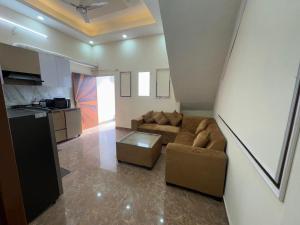 a living room with a couch and a kitchen at Harmony House in Ghaziabad