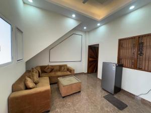 a living room with a couch and a tv at Harmony House in Ghaziabad