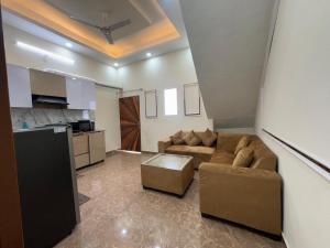 a living room with a couch and a kitchen at Harmony House in Ghaziabad