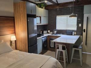 eine kleine Küche mit Bett und Tisch in einem Zimmer in der Unterkunft Leipoldt Self-Catering Accommodation in Secunda
