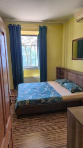 a bedroom with a bed with blue curtains and a window at Apartment Capt Seferovic in Donji Morinj
