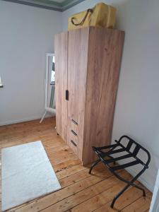 a wooden cabinet and a chair in a room at Pension Fiete Celle in Celle