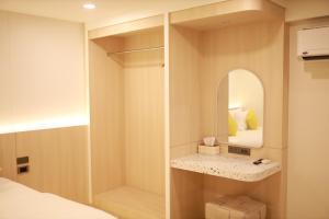 a small bedroom with a mirror and a bed at Kim Poshtel Hatyai in Hat Yai