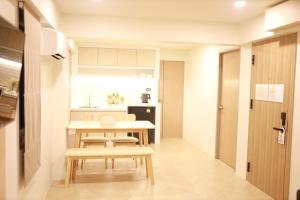 a small kitchen with a table and chairs in a room at Kim Poshtel Hatyai in Hat Yai
