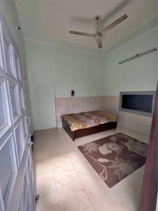 a room with a bed and a flat screen tv at Kunal Homestay in Rāmghāt