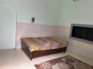 a bedroom with a bed and a flat screen tv at Kunal Homestay in Rāmghāt