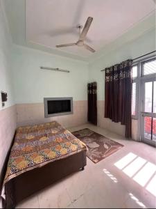 a bedroom with a bed and a ceiling fan at Kunal Homestay in Rāmghāt