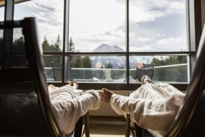 two children laying in chairs looking out of a window at Chalet Cristall Superior Appartement 3 in Leutasch +12 photos