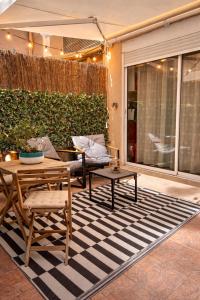 a patio with a table and chairs on a rug at Perle Dazur Jacuzzi Suite Parking Prive 5min Mer in Menton