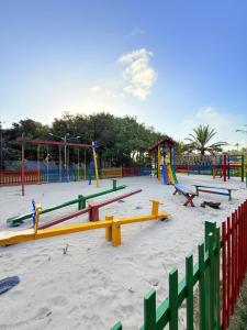 a playground with colorful play equipment in the sand at Portal do Sol Lençóis Pousada in Barreirinhas