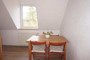 a dining room table with two chairs and a window at Ferienwohnung in Möllenhagen