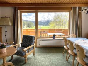 a room with a table and chairs and a large window at Chalet Cristall Superior Appartement 1 in Leutasch