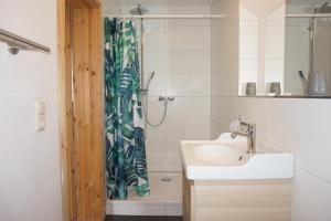 a bathroom with a sink and a shower curtain at Ferienwohnung in Möllenhagen +13 photos