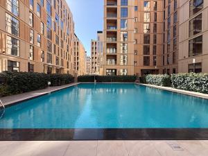 a large swimming pool in front of two tall buildings at Golden Sunset Luxe 1BR CB2-3-RA1-812-1br in Sabkhah