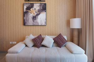 a living room with a white couch with pillows at Golden Sunset Luxe 1BR CB2-3-RA1-812-1br in Sabkhah +61 photos