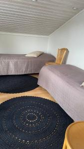 two beds in a room with a carpet on the floor at Kaliininkuja 1 in Lapua