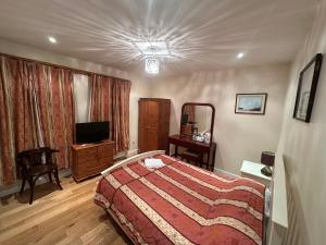 a hotel room with a bed and a television at The Dharma Lodge in Enfield