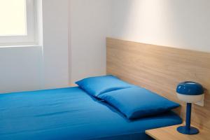 a blue bed with a wooden headboard and a blue pillow at Nila 1 by Huskalia in Los Llanos de Aridane