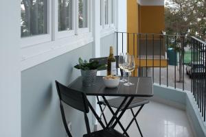 a table with a bottle of wine and glasses on a balcony at Nila 1 by Huskalia in Los Llanos de Aridane