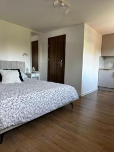 a bedroom with a large bed and a kitchen at Pokoje agroturystyczne U Hani in Ostrzyce