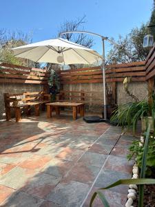 eine Terrasse mit Sonnenschirm, Tisch und Bänken in der Unterkunft Casa Ribe in Tui