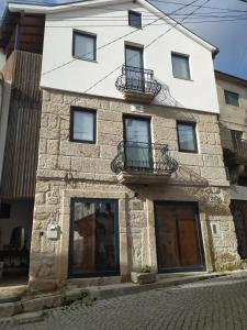 a stone building with two balconies on it at Azenha Ah Bô! in Alijó