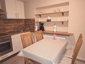a kitchen with a table and chairs and a sink at Ferienwohnung Naeve - helle, gemütliche Wohnung auf dem Lande mit zwei Schlafzimmern in Barderup