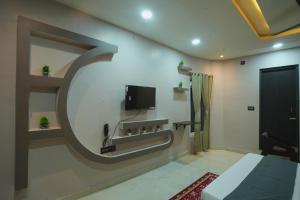 a room with a bed and a tv on a wall at Kasa Courtyard Hotel in Begusarai +30 photos