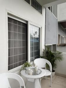 a patio with two chairs and a table and a window at HO6 Homestay in Guwahati