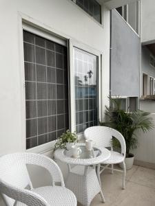 a patio with two chairs and a table and a window at HO6 Homestay in Guwahati