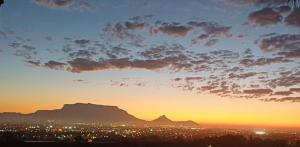 a sunset over a city with a mountain in the background at Plattekloof Mountain view in Plattekloof