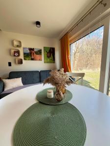a white table with a green plate on top of it at Domek Ranczo Podkówka "przed" Bieszczady in Lipa