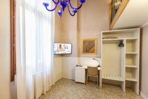 a room with a desk and a chandelier at Foresteria Levi in Venice