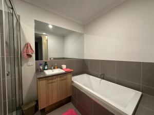 ein Badezimmer mit Badewanne und Waschbecken in der Unterkunft Your Guest House in Tarneit